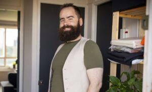 Property guardian standing in their doorway smiling.