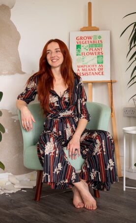 A Dot Dot Dot guardian sitting on a chair smiling.