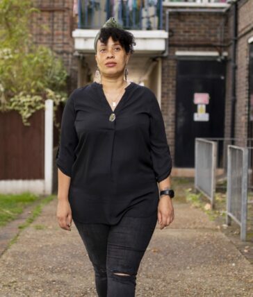 Dot Dot Dot guardian walking in front of block of flats.