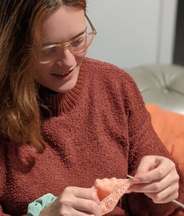 Guardian knitting a hat for newborn baby.